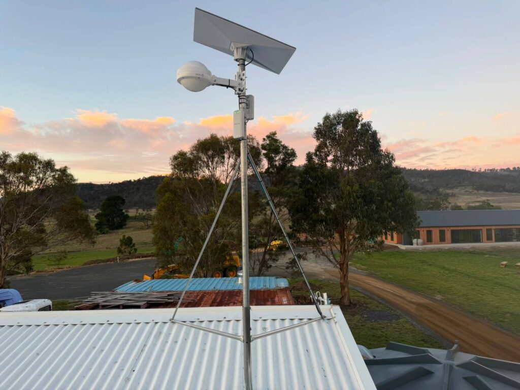 Starlink dish and outdoor WiFi 6 access point mounted on a guyed mast above a shed roof at Mapleton Vineyard, Tea Tree, Tasmania