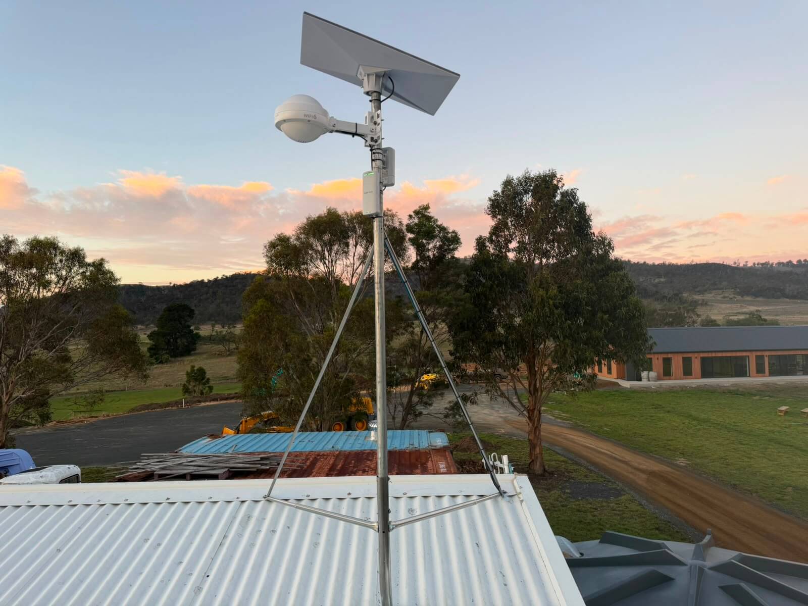 Starlink dish and outdoor WiFi 6 access point mounted on a guyed mast above a shed roof at Mapleton Vineyard, Tea Tree, Tasmania