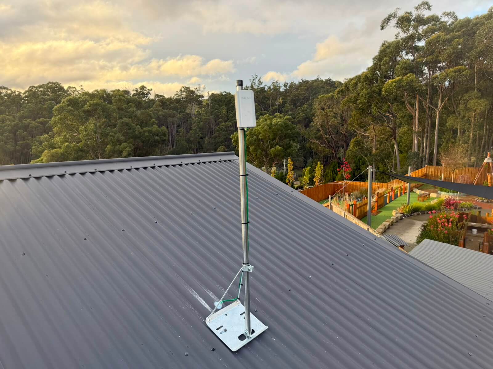Point to point WiFi receiver mounted on a braced roof mast above the childcare centre at Muddy Puddles, Huonville, Tasmania