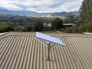 Starlink dish on a braced pole mount on a roof overlooking the Huon Valley in Huonville, Tasmania