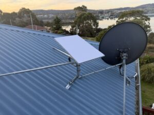 Starlink dish on a braced roof mount beside a satellite TV dish in Primrose Sands, Tasmania