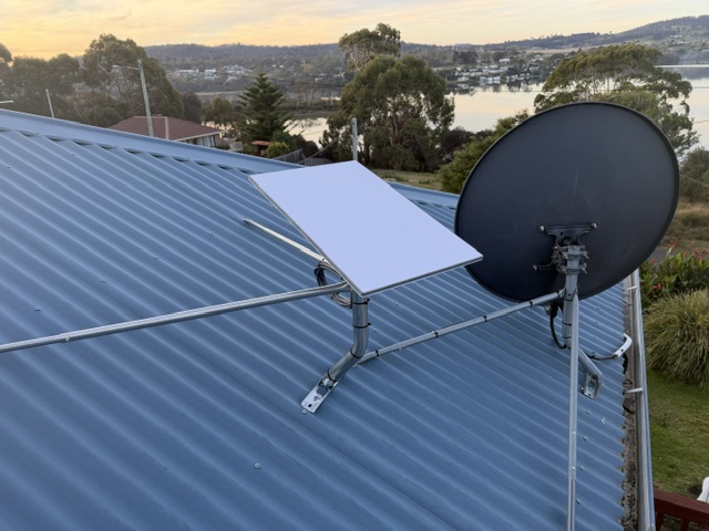 Starlink dish on a braced roof mount beside a satellite TV dish in Primrose Sands, Tasmania