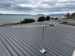UHF TV antenna on a roof mast overlooking the water in South Arm, Tasmania