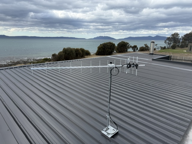 UHF TV antenna on a roof mast overlooking the water in South Arm, Tasmania